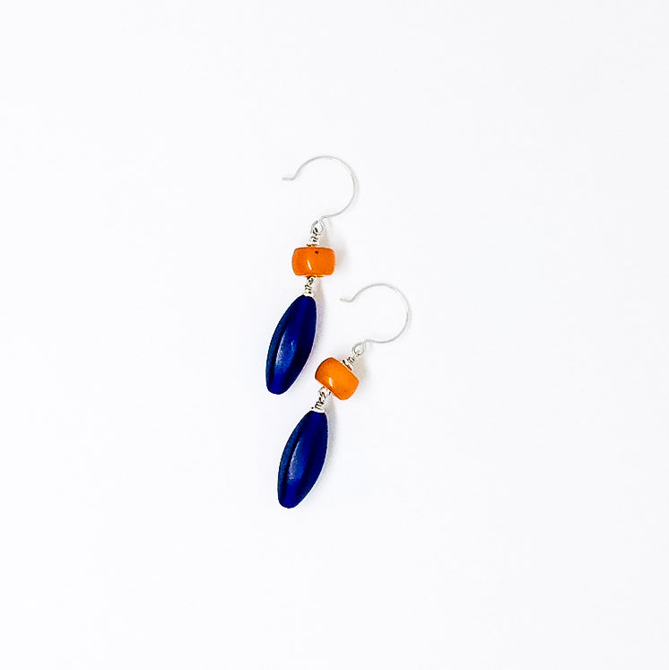 Contrasting orange resin and cobalt Czech glass drop earrings flat lay